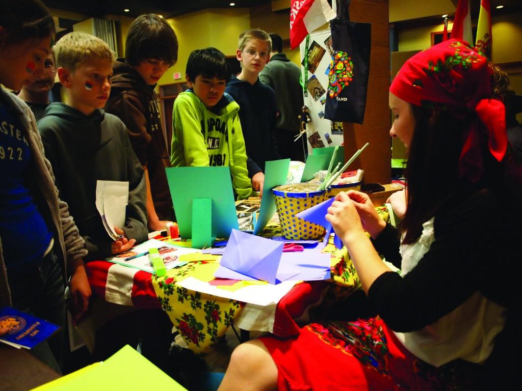 Ewa Wantulok, senior from Wisla, Poland, shows a group of students from several regional elementary, middle and high schools how to make a display from construction paper. There were more than 27 countries represented at the Internation Education Week in total. || Beamer Barron/The News