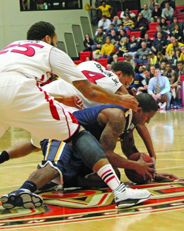 Senior Isaiah Canaan struggles with the Cougars defense to remain in control of the ball during the Racers’ loss to SIUE Thursday night in Edwardsville, Ill. The Racers, who usually dominate the second half, struggled to make shots, shooting only 31 percent from the field and 18 percent from 3-point range. || Taylor McStoots/The News