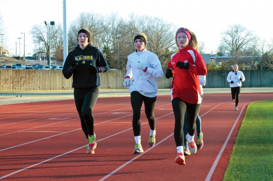 Jenny Rohl/The News
Juniors Brittany Bohn (left) and Abbie Oliver (right) run around the track in a morning practice.
