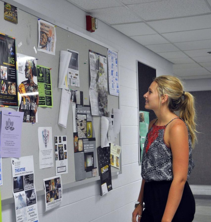 Kylie Townsend/The News
Art major Abby Murdock, junior from Murray, looks at the upcoming events offered by the theater department.