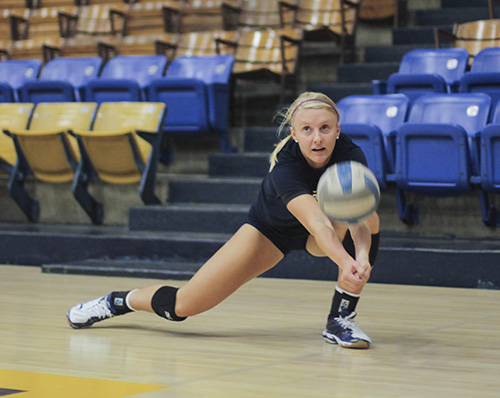 Jenny Rohl/The News Junior Emily Schmahl digs for a ball during practice in Racer Arena. The Racers are undefeated in tournament play and are looking forward to the start of regular season.