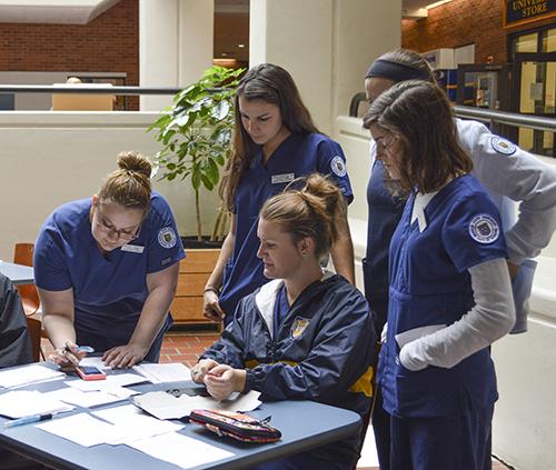 Hannah Fowl/The News
Health Services employees and nursing students tally the number of vaccines administered at the flu shot clinic.