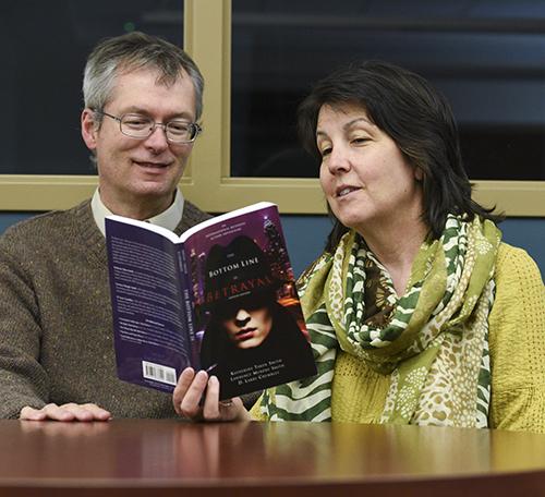 Kory Savage/The News
Professors Lawrence Murphy and Katherine Smith look at their novel, “The Bottom Line is Betrayal.”