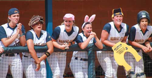 Jenny Rohl/The News
The Racer softball team cheers on their teammates with their hats turned inside out, backward or upside down in superstition while a player bats.