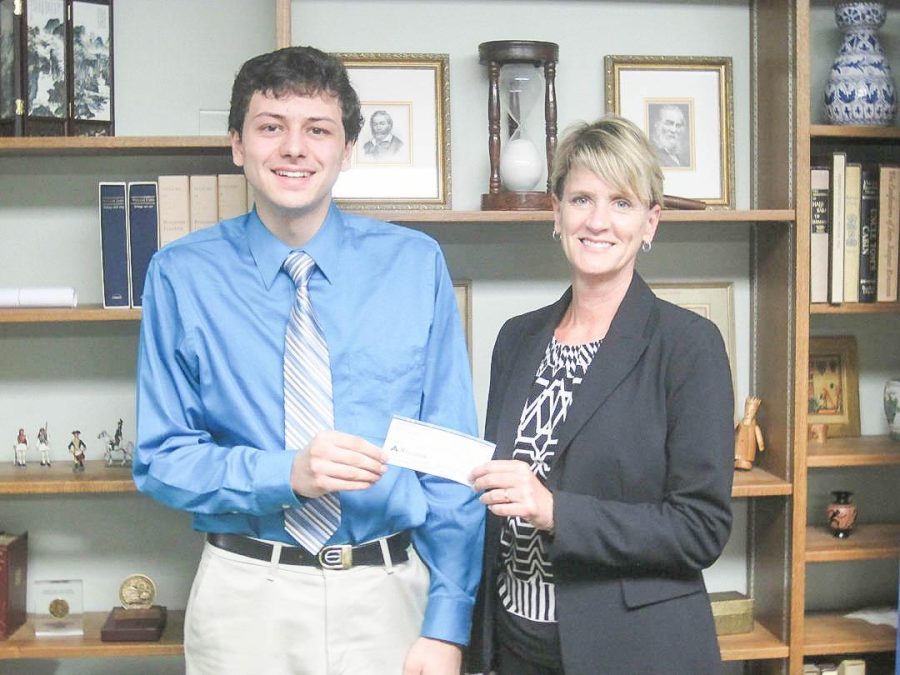 Ray Chumbler IV gives a check to Jennie Rottinghaus, director of development, to establish the scholarship. Photo courtesy of WKMS
