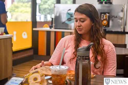 Sophomore Jenna Howard enjoys her first breakfast at the recently opened Einstein Bros. Bagels. (Lauren Morgan/The News)
