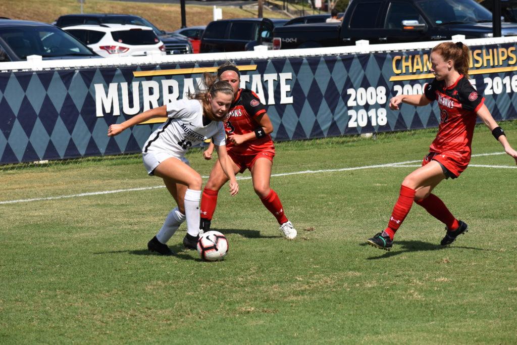 Izzy Heckman controls the ball with two defenders rushing her. (Photo by Gage Johnson/TheNews)