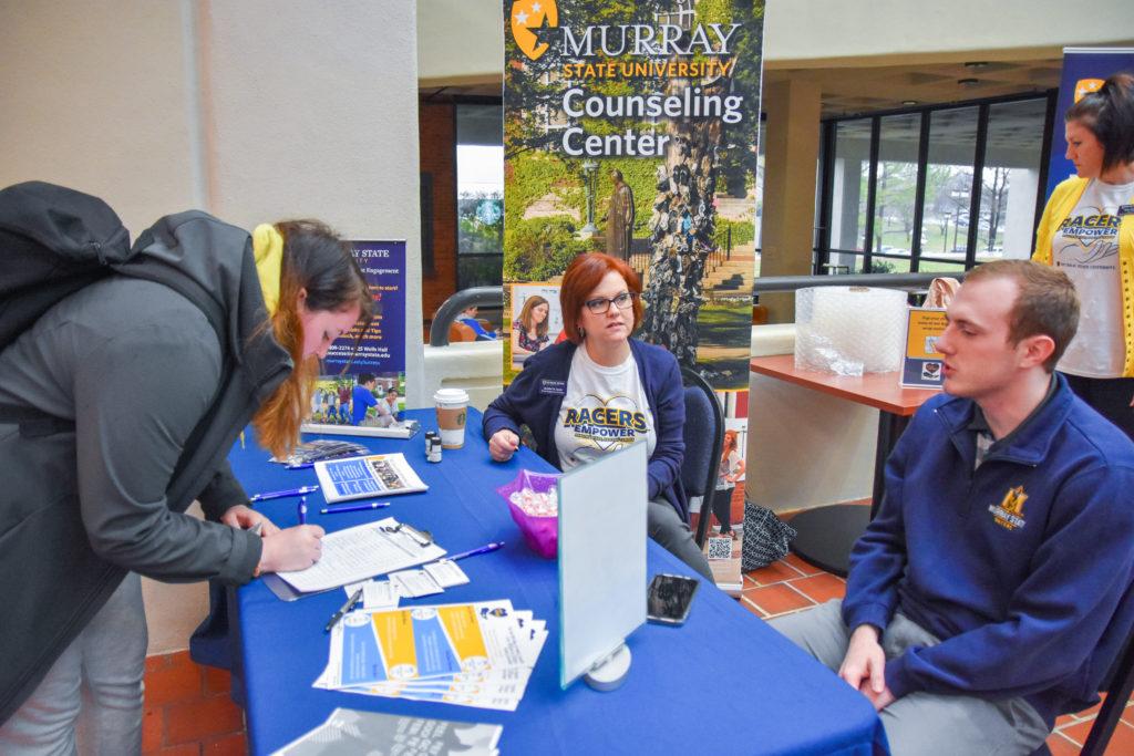 Coordinator for the Office of Student Engagement and Success Jennifer Smith and Student Government Association President Trey Book provide tips about mental health to a student. (Jillian Rush/The News)