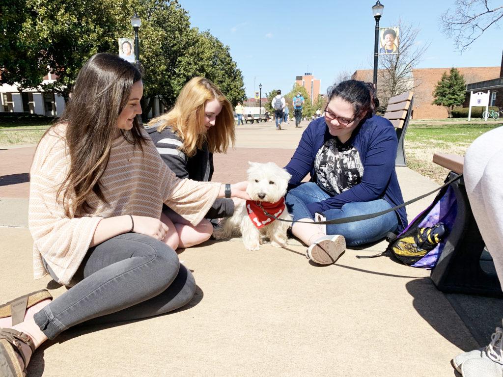 Students Kaley Holland, Sheri Raulerson and Heavyn Taylor enjoy Pet Therapy. (Cady Stribling/The News)