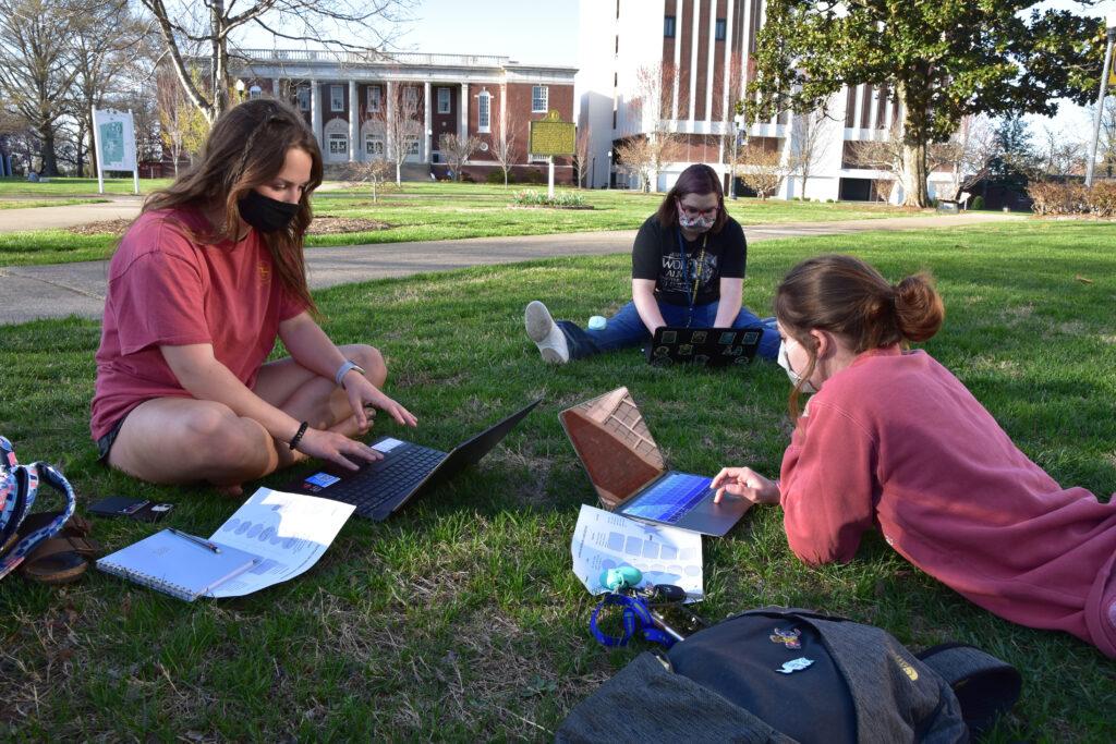 Freshmen Emily Twellman, Taylor Groves and Sophomore Alexa Wesley took time to go outdoors and do schoolwork. (Jillian Rush/The News)