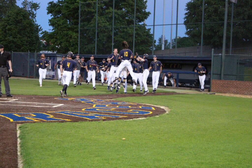 The Racers mob senior outfielder Ryan Perkins after he crosses home plate for the walk-off win against Belmont. (Photo by Simon Elfrink/The News)