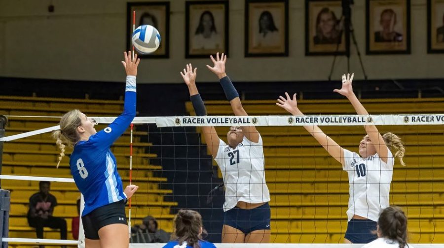 Junior outside hitter Jayla Holcombe and graduate middle blocker Elisa Dozio attempt to block a spike from an opposing attacker. Photo courtesy of David Eaton/Racer Athletics.
