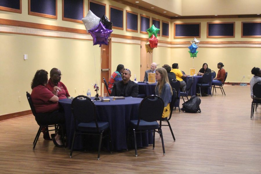 Attendees mingle at conversation tables mixed with students and staff members. (Dionte Berry/The News)