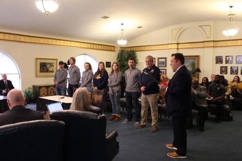 Athletic Director Nico Yantko presents the rifle team with awards at a Board of Regents meeting on Feb. 24 (Dionte Berry / The News).