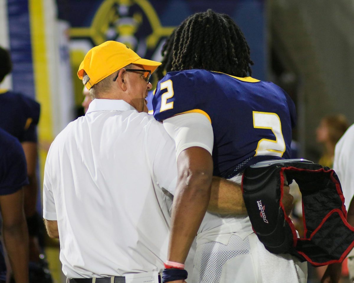 Head Coach Dean Hood and sophomore quarterback DJ Williams share a moment after the Racers 41-10 win over Presbyterian College.