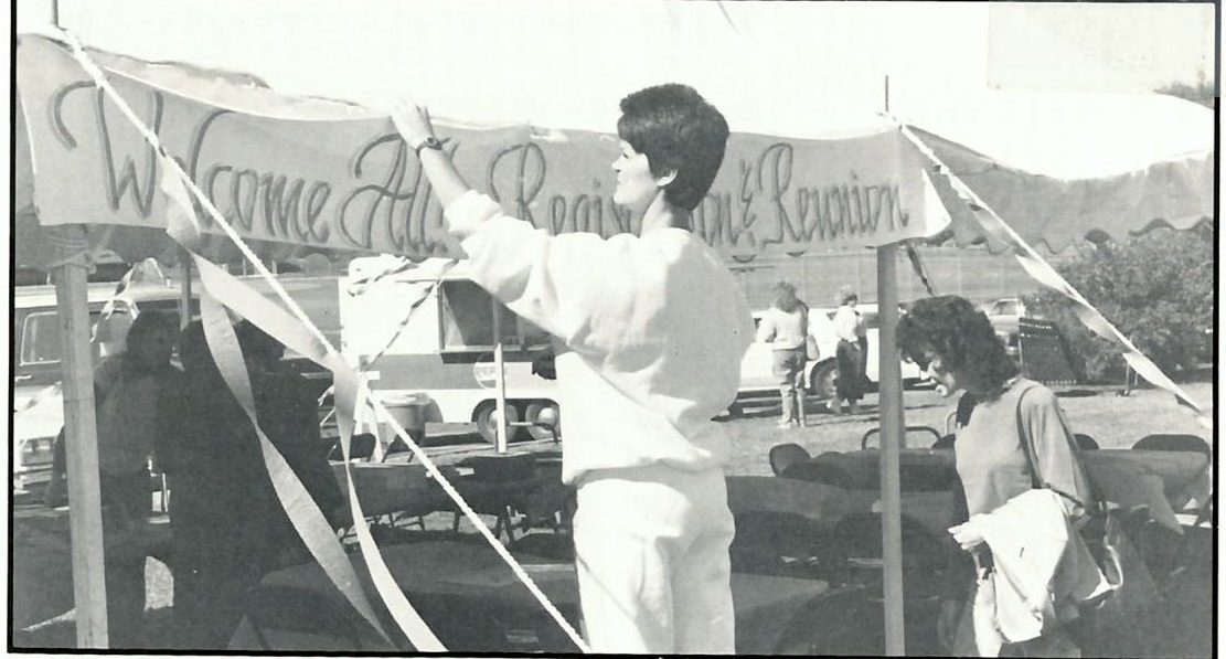 Patti Jones puts up a welcome banner at the first Tent City. Photo from 1990 The Shield.