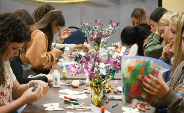 Students work on their own personal Mardi Gras mask. This was the activity at French table at the Global Languages Workshop.