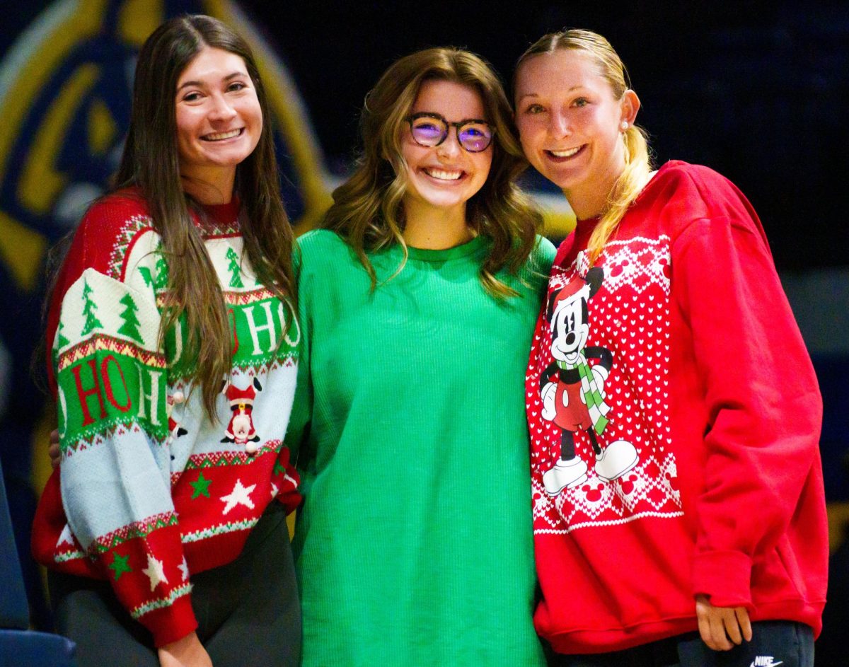From left to right: Halle Langhi, Neely Northcott (team manager) and Charlee Settle sport Christmas sweaters to celebrate the season. 