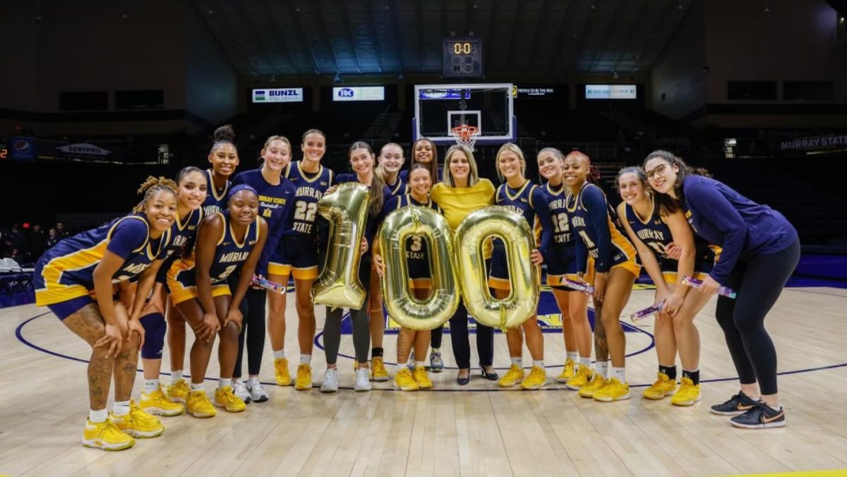 The Murray State womens basketball team poses with Head Coach Rechelle Turner after her 100th win. Photo courtesy of David Eaton/Racer Athletics.