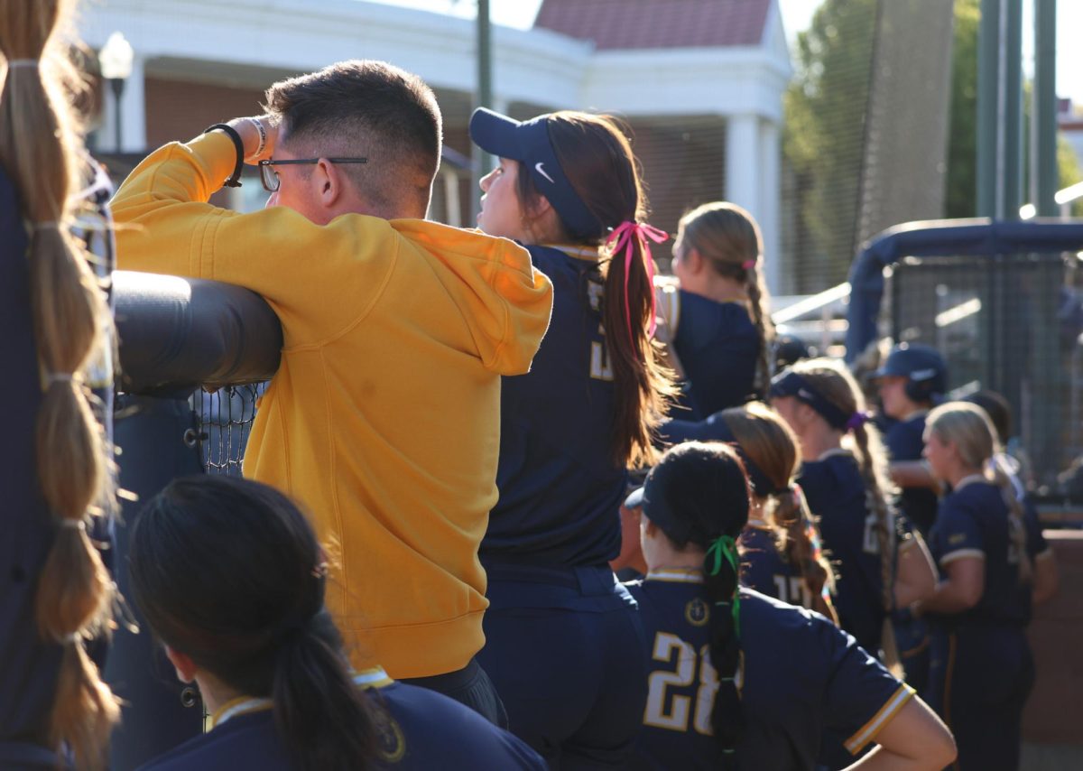 The Racers softball team in the dugout during the game.