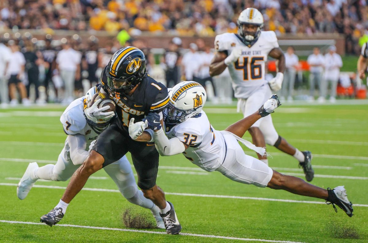 Linebacker Justice Cross and defensive back Lovie Jenkins tackle a Mizzou player.