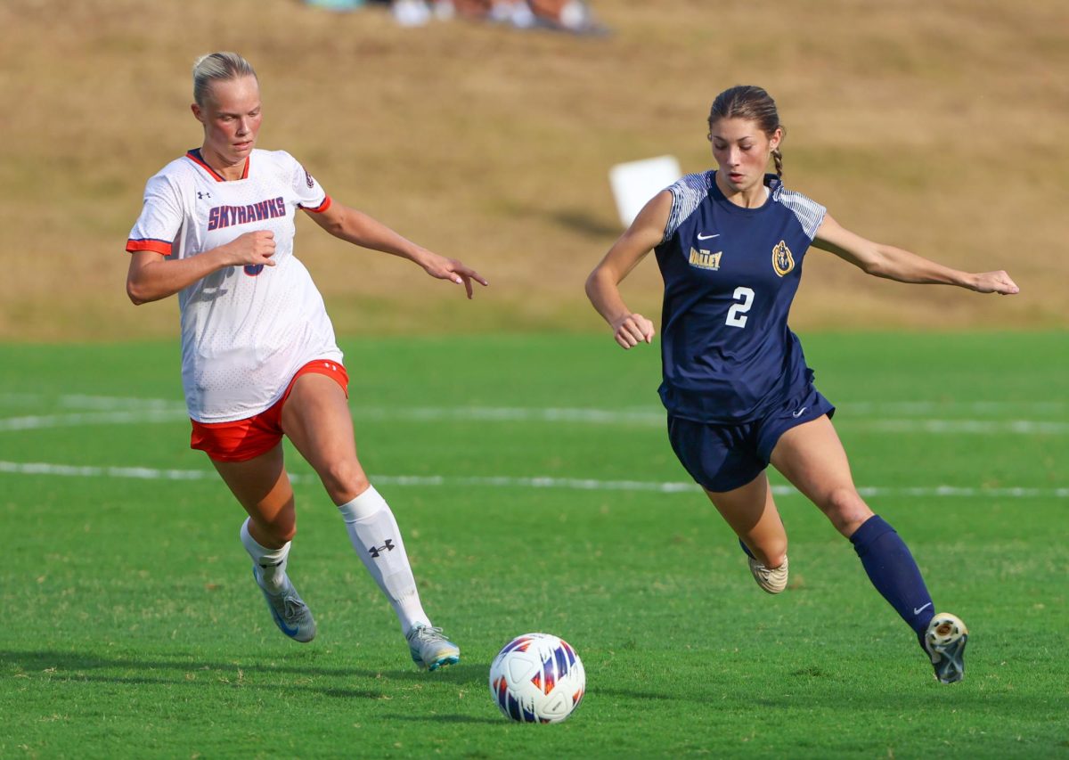 Freshman forward Breece Bass chases after the ball alongside a Skyhawk player. 