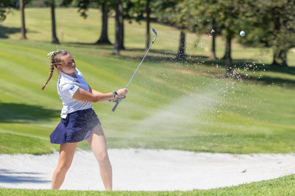 Freshman Elin Tynan hits out of the bunker. 