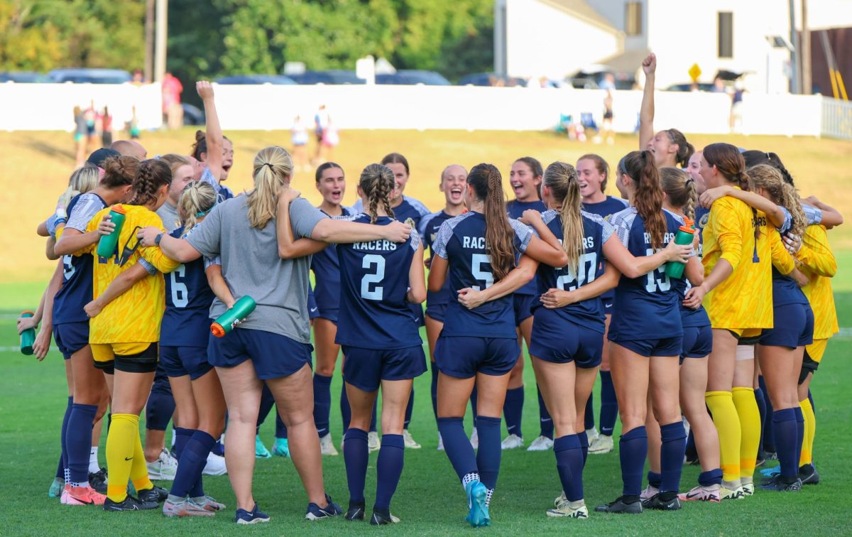 The team celebrates their win in a huddle after the game. 