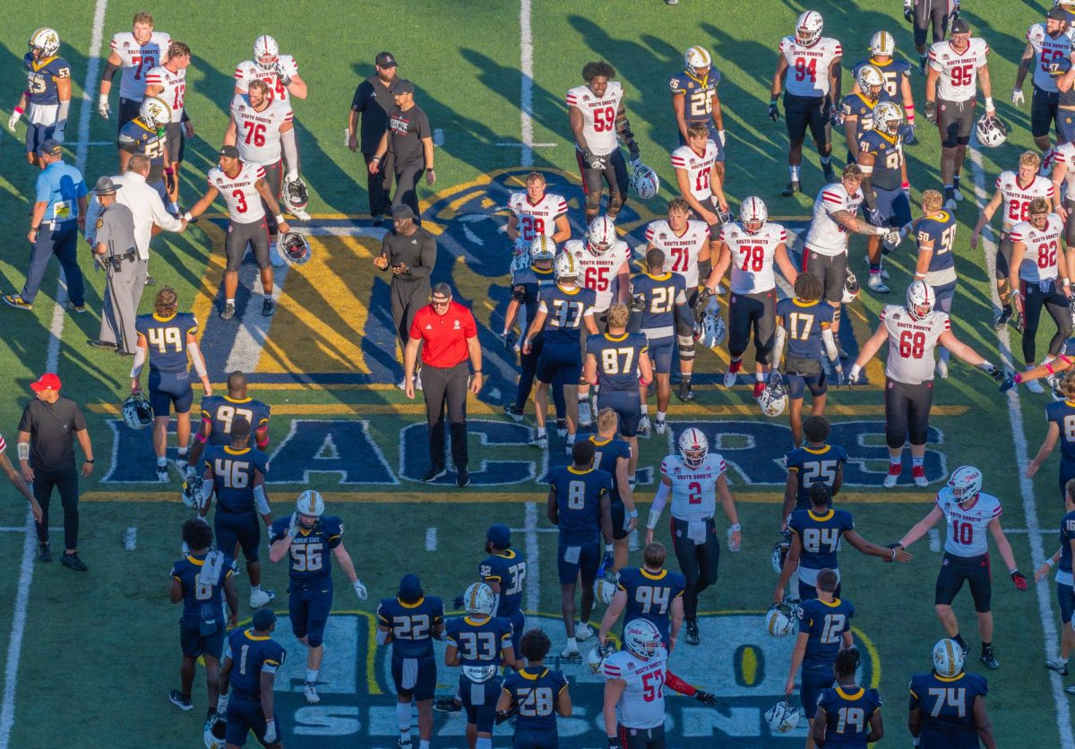 Both teams meeting to shake hands after the game has ended. 