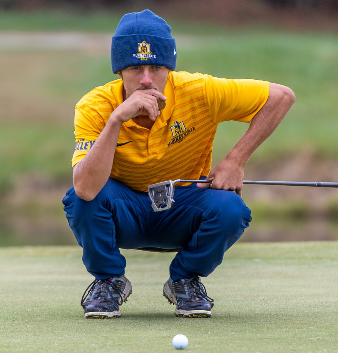 Redshirt sophomore Rocco Zakutney reads the green before putting. 