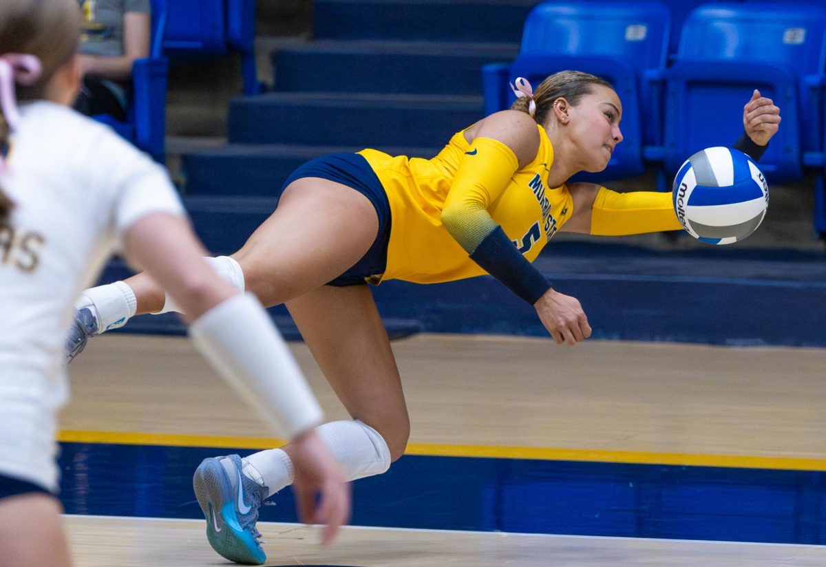 Graduate student libero Dahlia Miller makes a diving hit. 