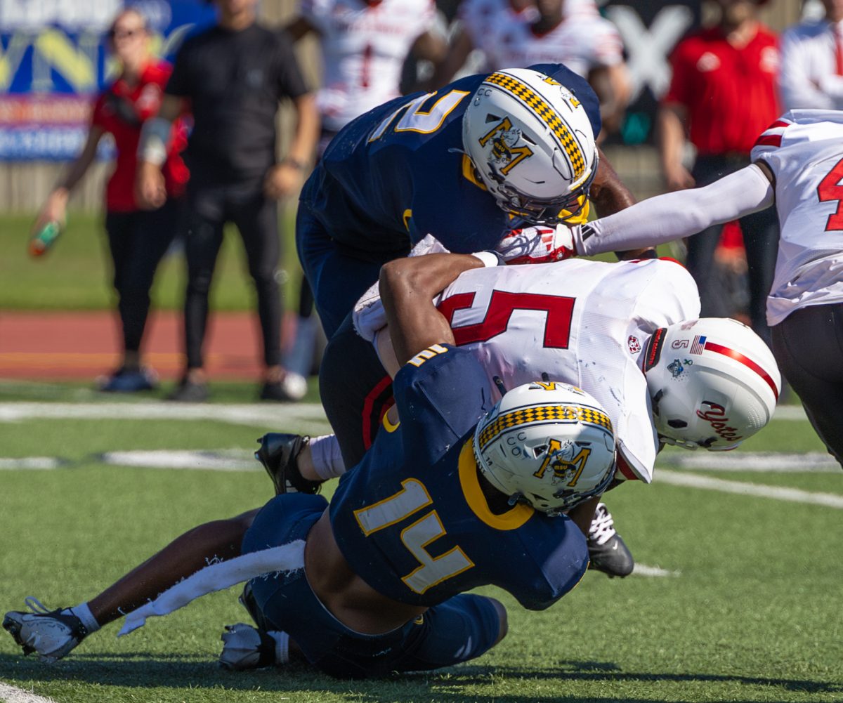 Junior defensive back Larry Preston and senior outside linebacker Jamari Dailey tackle a South Dakota player. 