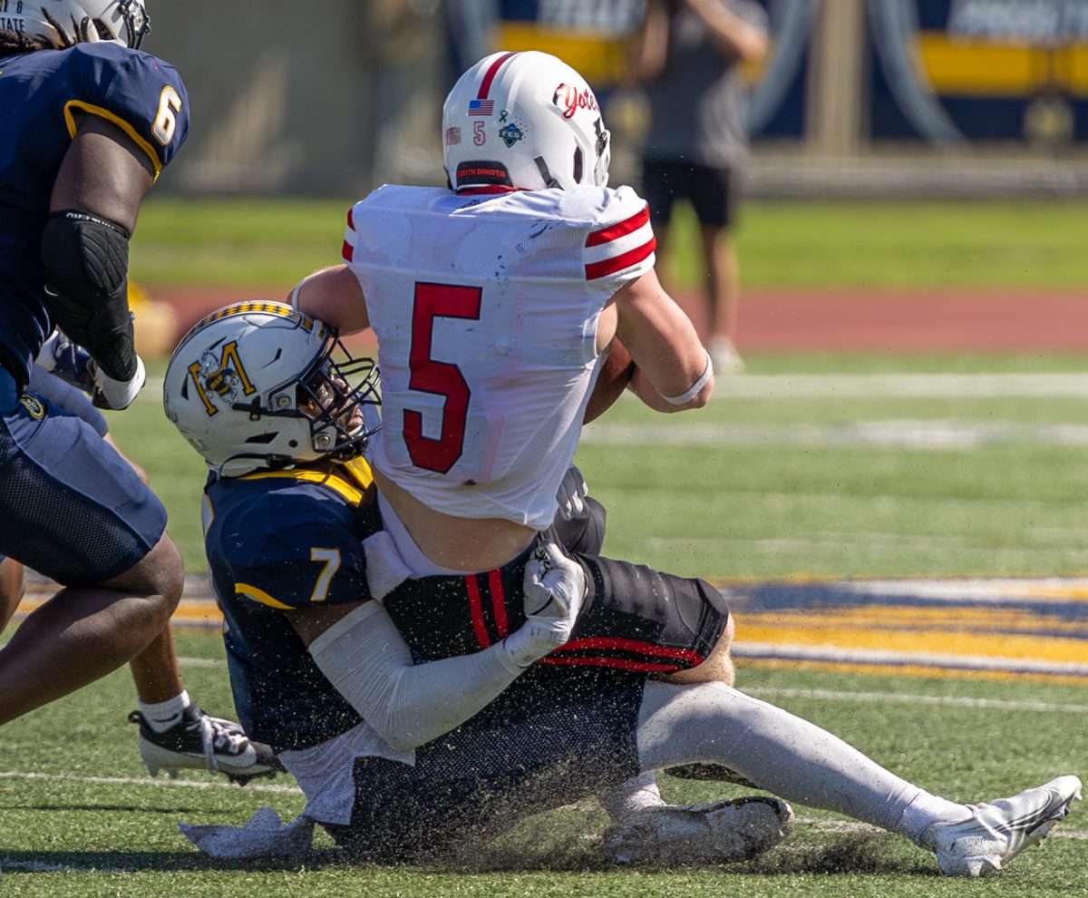 Graduate student linebacker Justice Cross tackling a South Dakota player. 