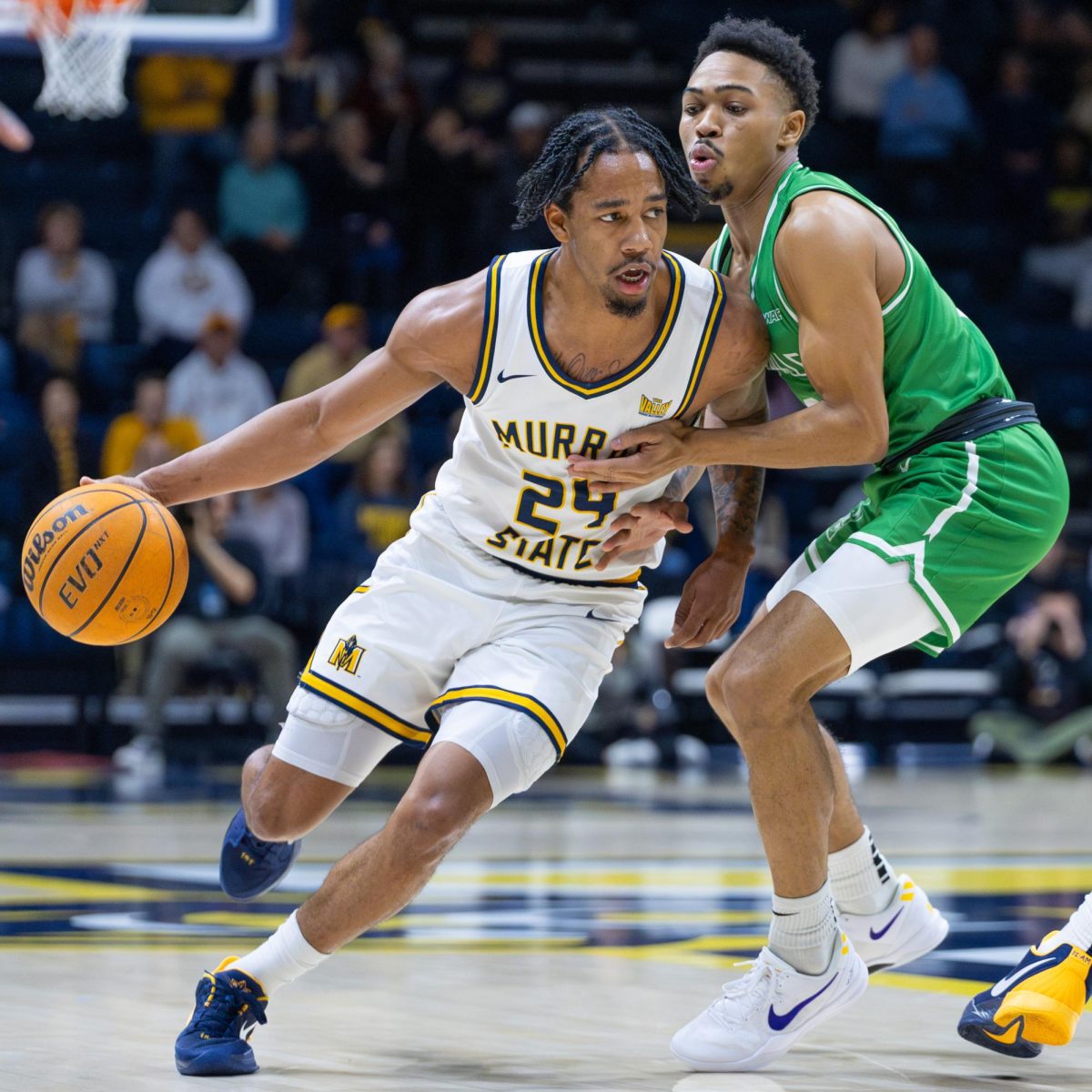 Senior guard JaCobi Wood drives around a Utah Valley defender.