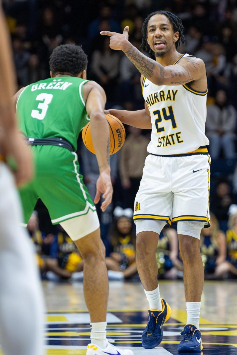 Senior guard JaCobi Wood motions to his teammates. 