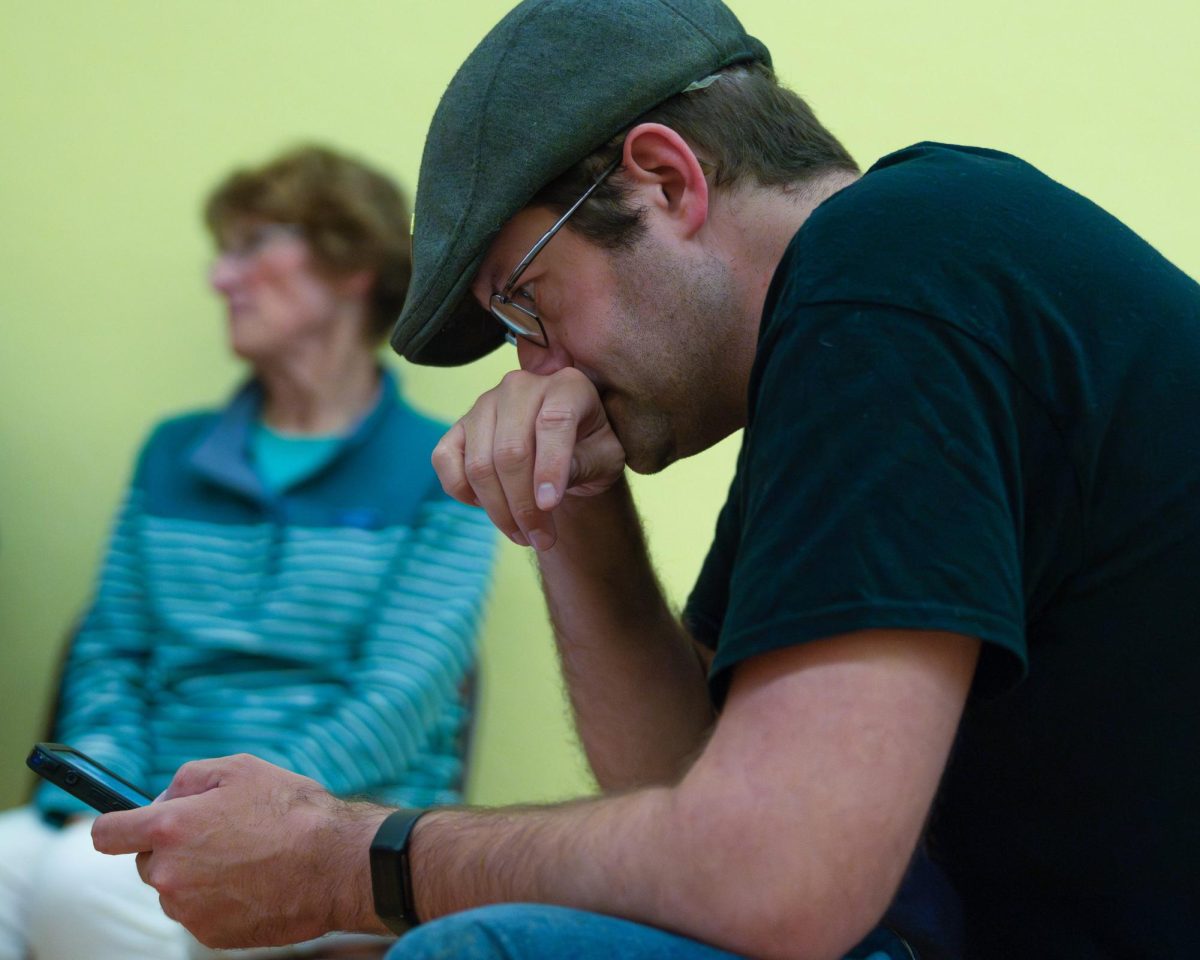 A Democratic party supporter watches results come in on their phone. 