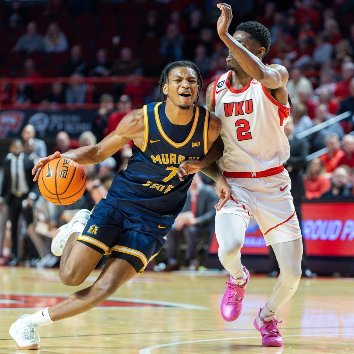 Senior guard AJ Ferguson drives by a WKU defender.