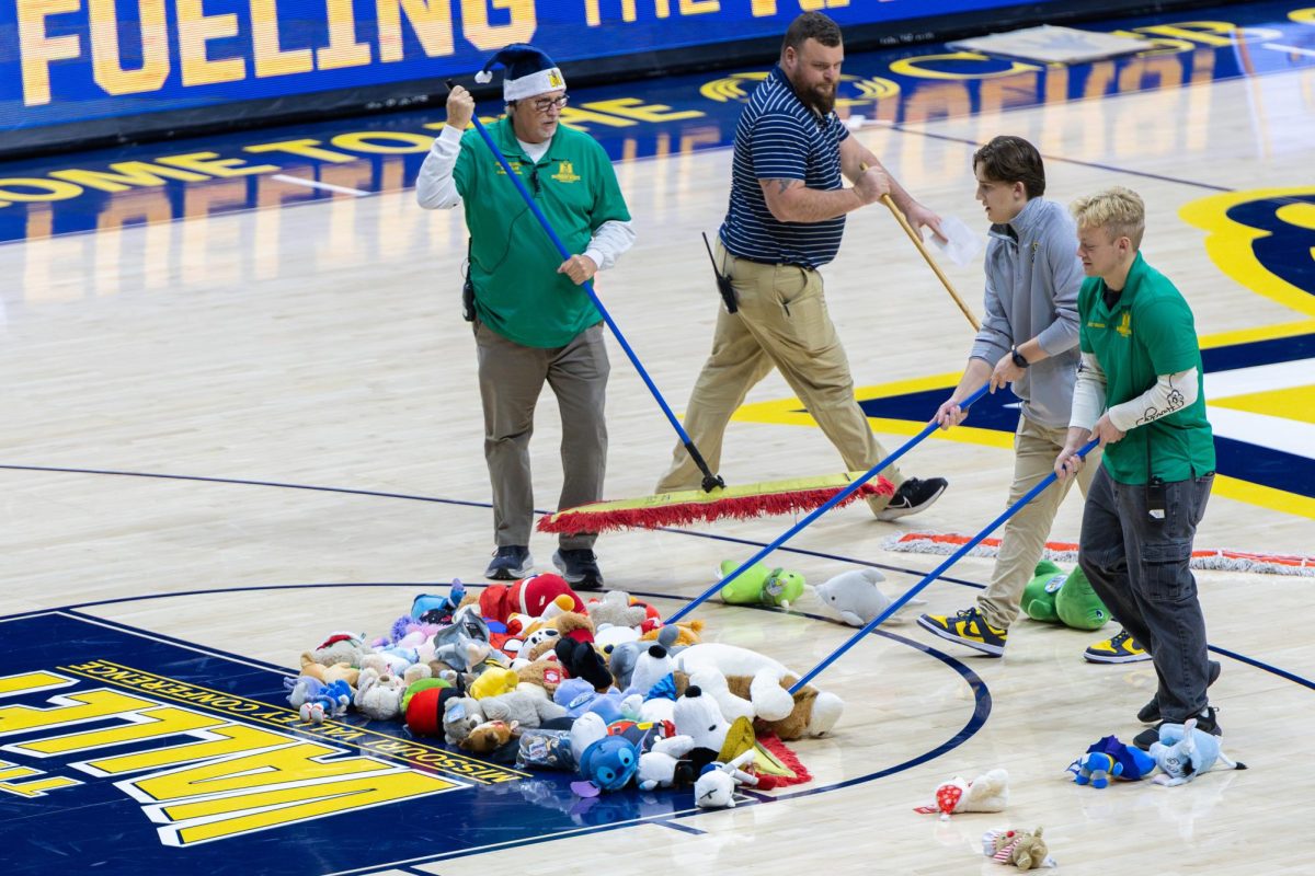 Murray State Athletics workers sweeping up the court after the Teddy Bear Toss.