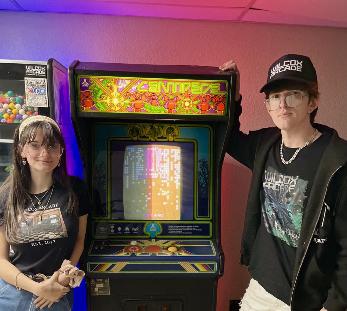 Harrell (left) and Wilcox (right) pose next to one of the arcade games owned by Wilcox Arcade at Trends N Treasures. 