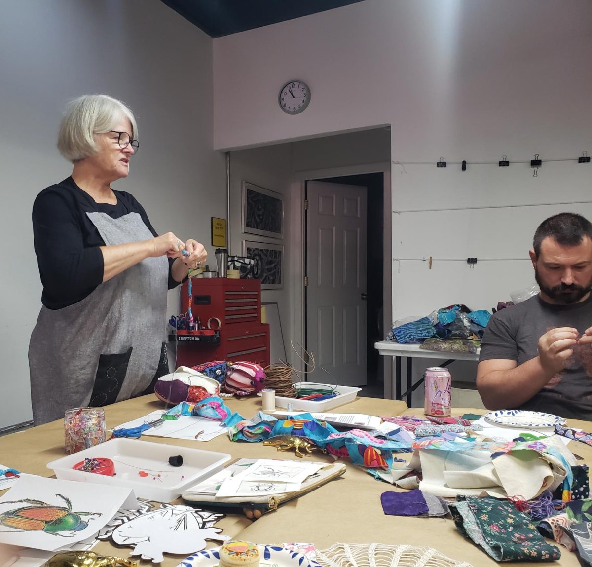 Debi Danielson teaches workshop attendees to wrap wire legs in "Scrappy Beetles" workshop.