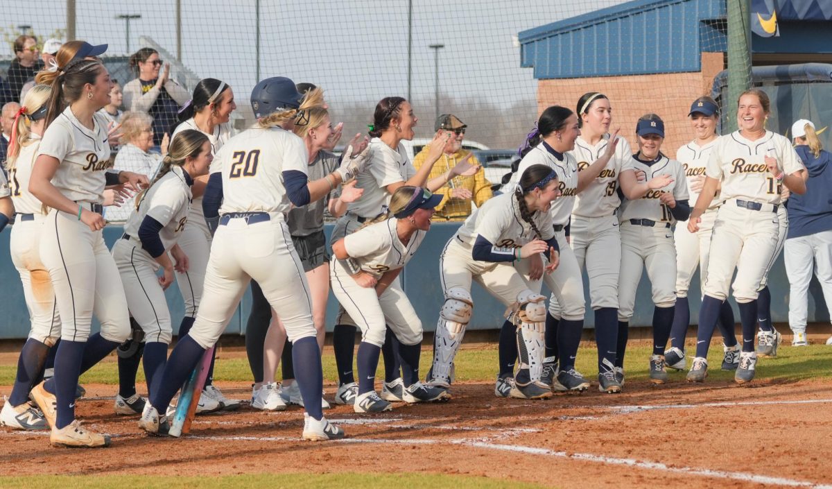 Racers wait at home plate to congratulate teammate Kenley Minor after hitting a homerun. 
