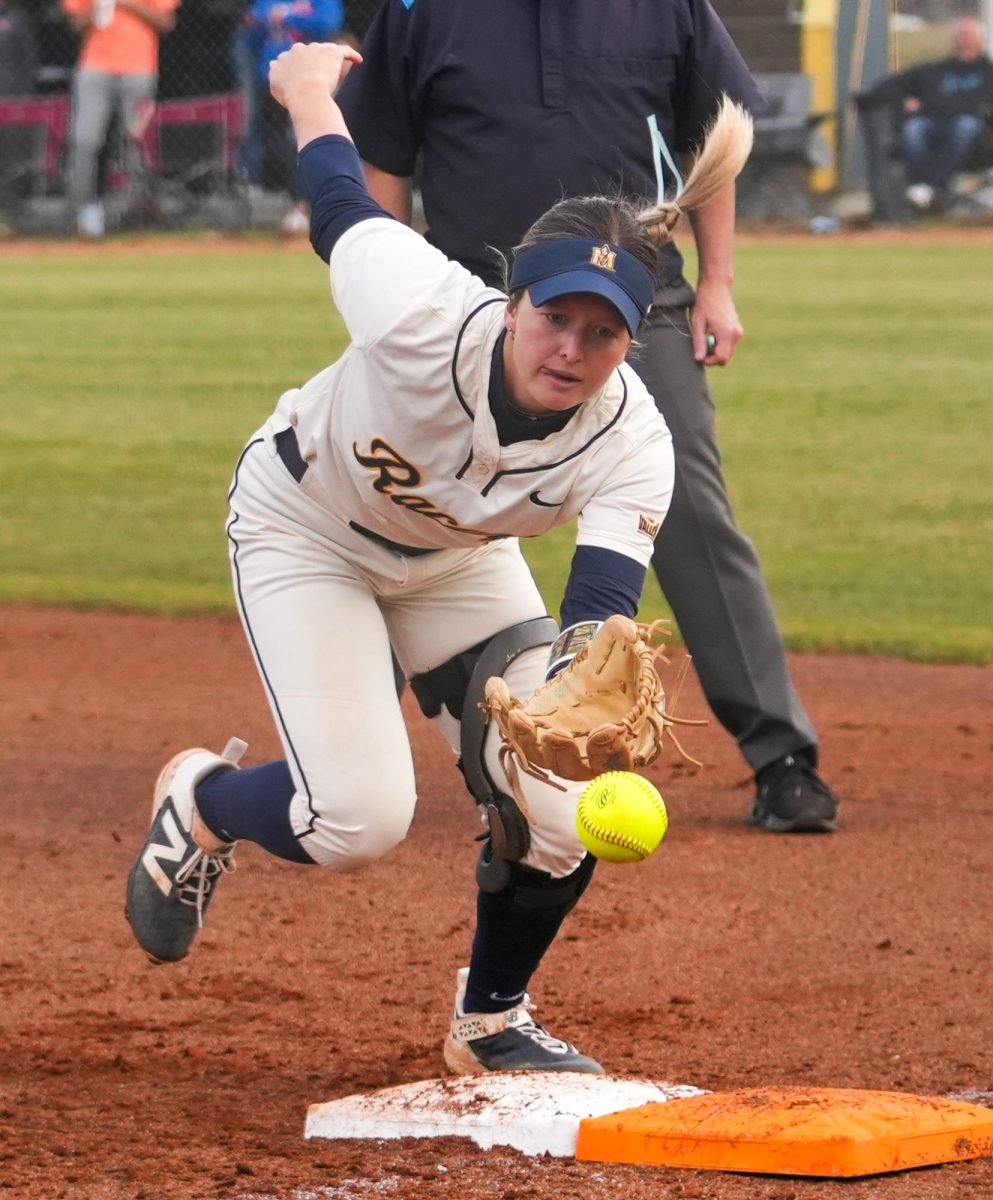 Junior Adison Hicks diving for the ball at first base.