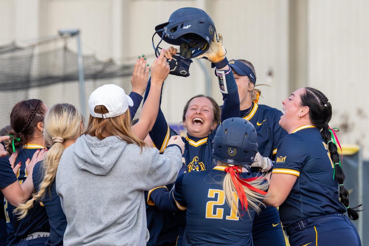 Redshirt junior utility player Adison Hicks celebrates with teammates after driving in the winning run. 