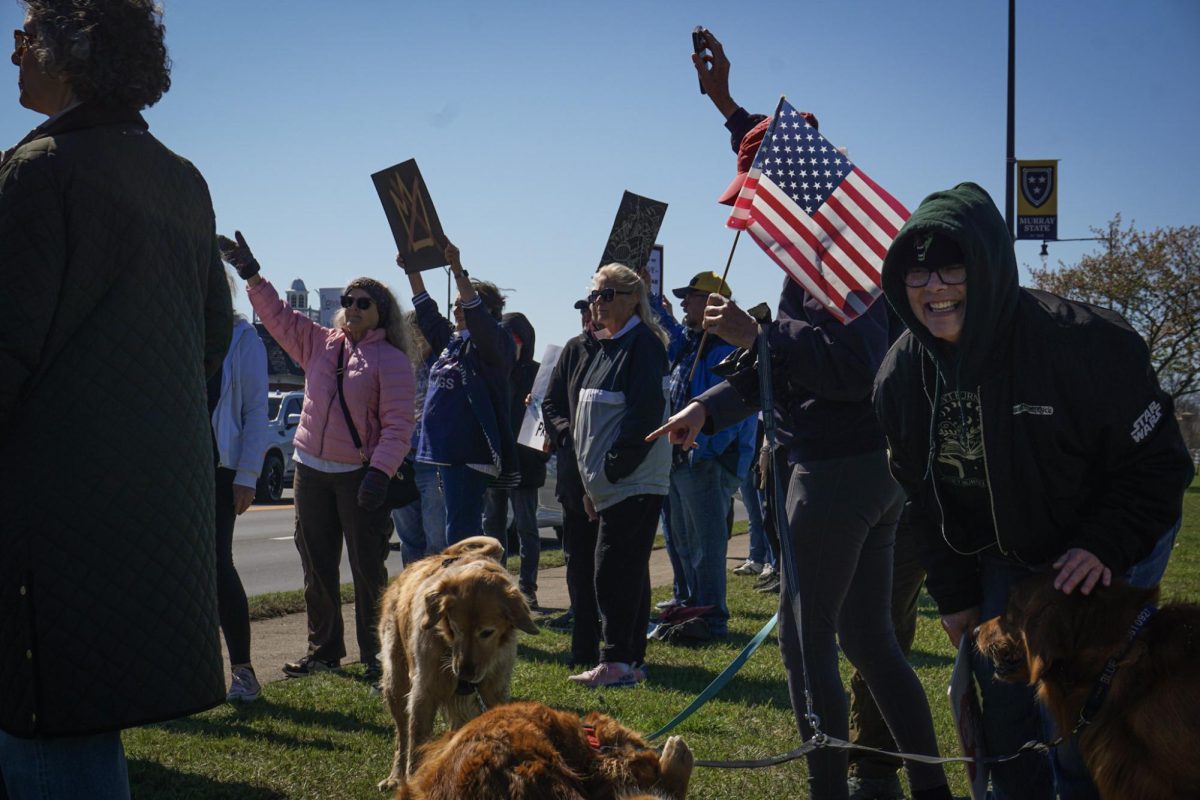 Letisha Usher plays with Barbara Philips's "anti-fascist" golden retrievers at a No Kings Protest in Murray, on March 28, 2026. 