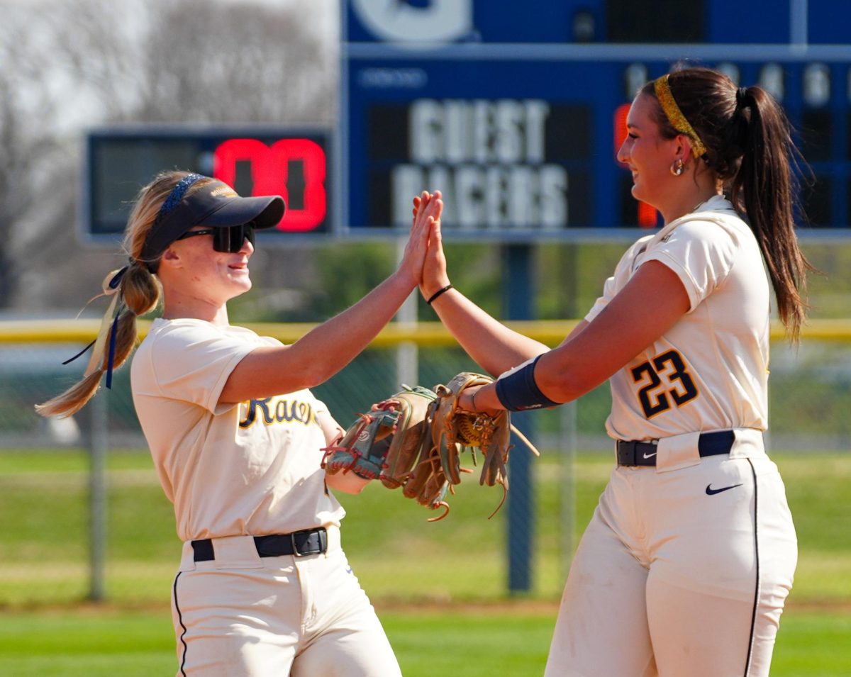 Freshman Pitcher Hailey Brereton and sophomore Infield  Kenley Minor high fiving before the inning starts. 